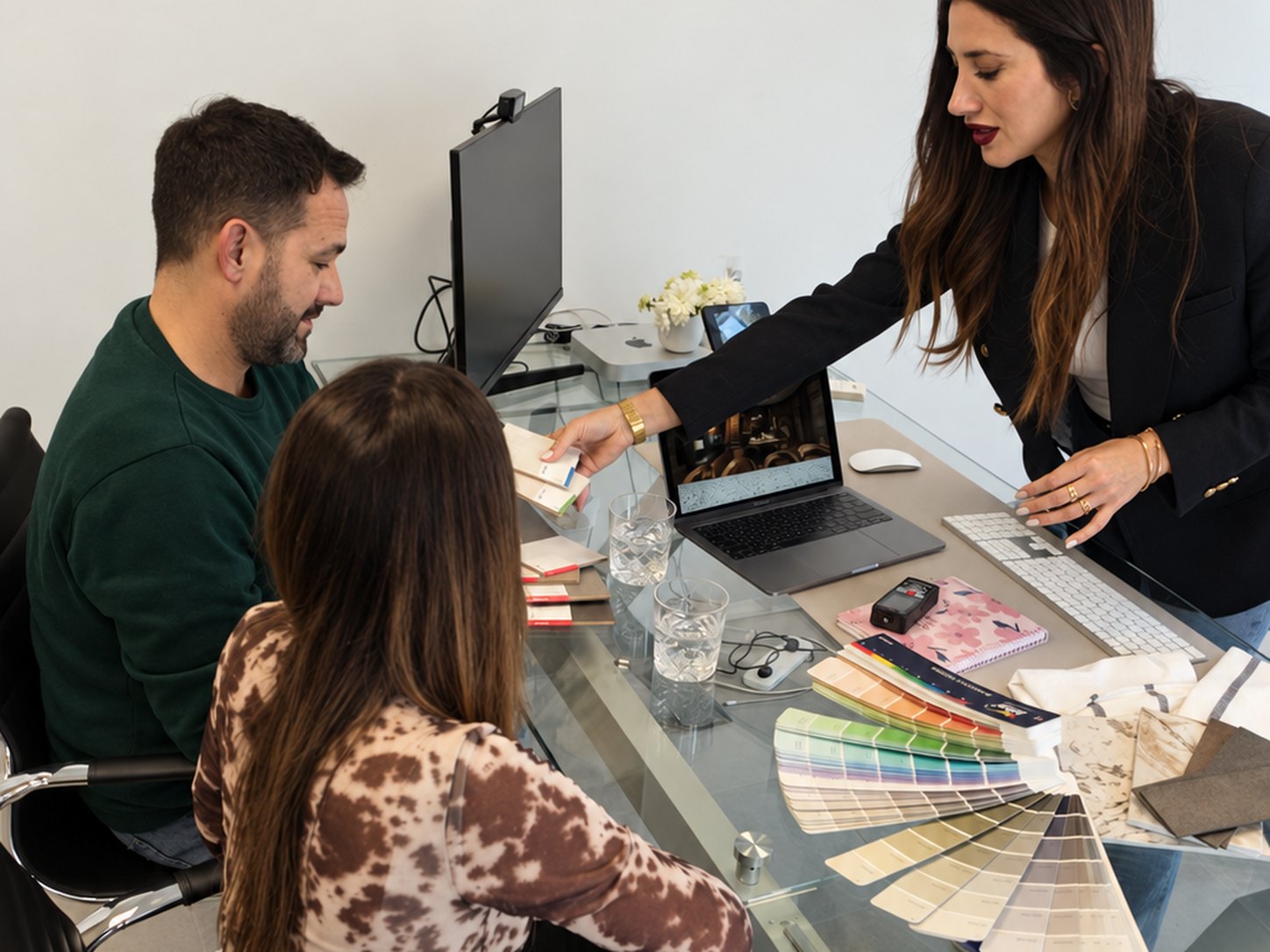 Lola Lloret presentando el proyecto a una pareja de clientes con muestras de color